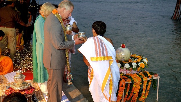 The Prince of Wales and Duchess of Cornwall are given water to pour into the river Ganges.