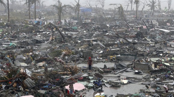 Survivors stand among debris and ruins of houses destroyed after Super Typhoon Haiyan battered Tacloban city in central Philippines.