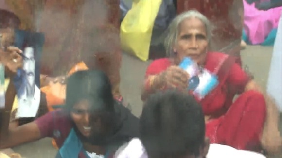 Women holding pictures of their missing relatives stage a sit-down protest in Jaffna, Sri Lanka.