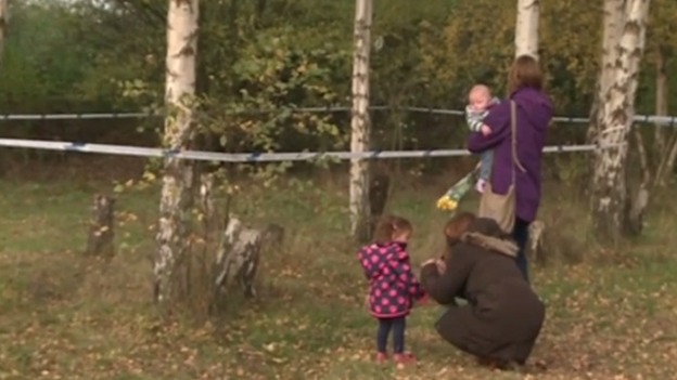 Friends lay flowers at the spot a body was found
