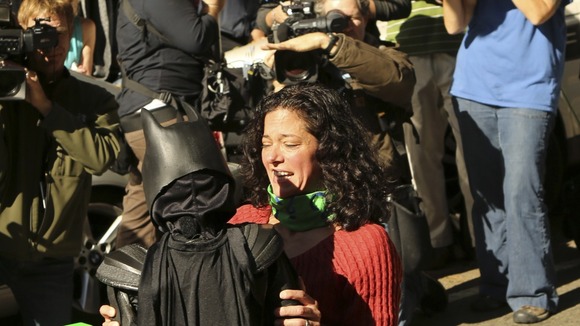 Batman is hugged after "rescuing a woman".