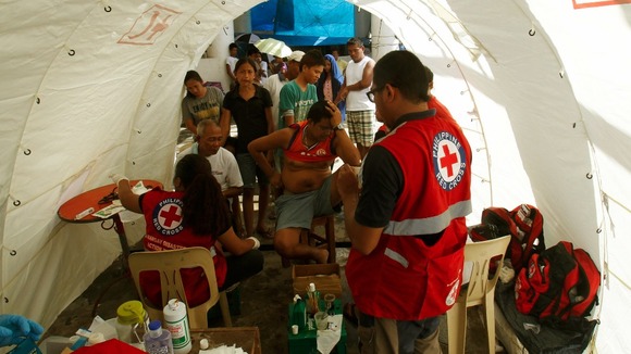 Residents receive medical aid from the Philippine Red Cross outside their temporary shelters in Tacloban.