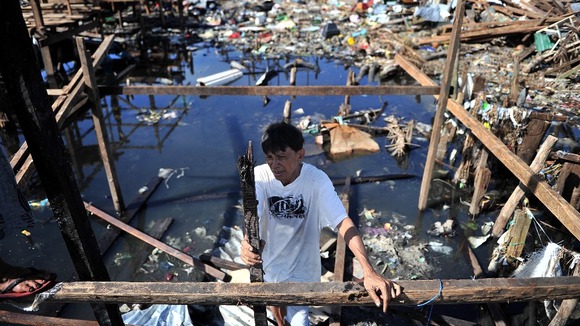 A Filipino man is seen amongst the ruins of typhoon-ravaged Tacloban city in the Philippines.
