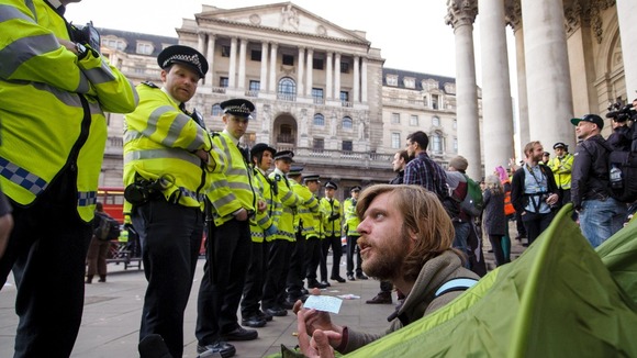 An Occupy demonstrator inside a tent speaks with police officers