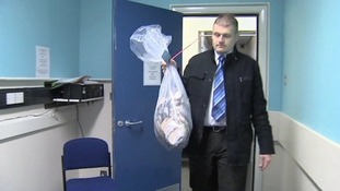 Detective Inspector Steve Hull, from Lincolnshire Police, carries the money in for investigation.