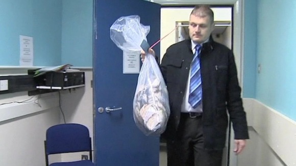 Detective Inspector Steve Hull, from Lincolnshire Police, carries the money in for investigation.