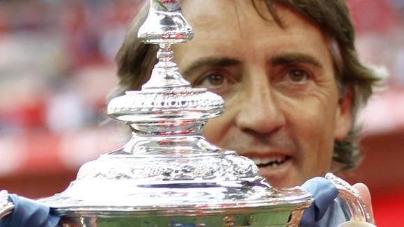 Manchester City manager with the FA Cup trophy in 2011
