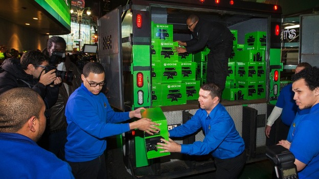 Best Buy employees work to unload an armoured vehicle filled with Day One edition Xbox One consoles for a midnight launch event in New York