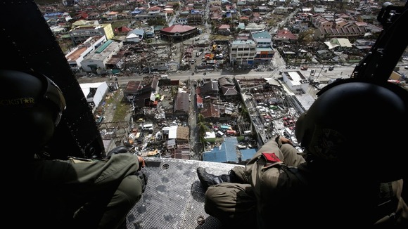 Members of the Philippine Air Force survey the damage in Tacloban from the air