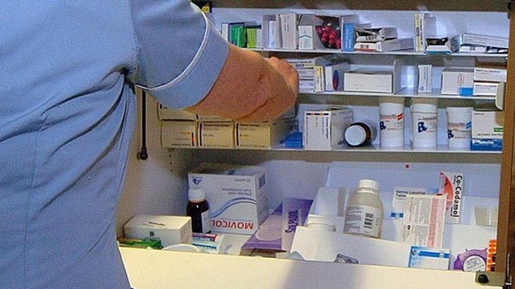 Member of nursing staff dispensing drugs from a trolley on a ward
