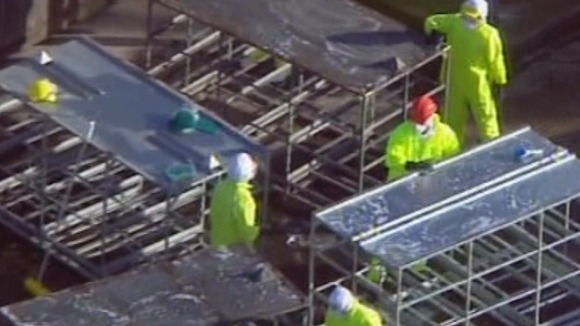 Workers disinfecting poultry sheds after a previous infection