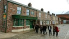 Cast members from Coronation Street walk along the cobbles of the new set.
