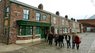 Cast members from Coronation Street walk along the cobbles of the new set.