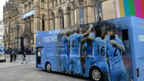 An open top bus arrives at Albert Square ahead of Manchester City's parade through the city.