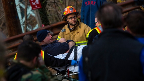 Man taken away on stretcher at site of Metro-North train derailment.
