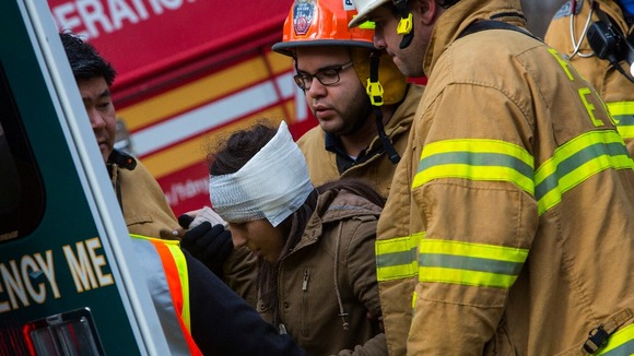 Woman taken to an ambulance at thesite of Metro-North train derailment.