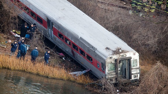 Emergency workers examine the site of a Metro-North train in New York City.