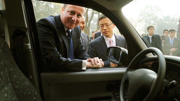 Prime Minister David Cameron looks at a black cab with Geely Chairman Li Shufu.