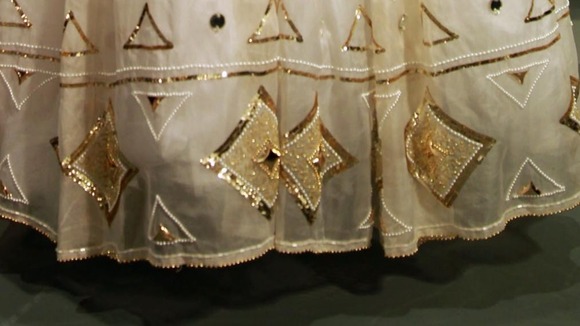 The dress features crystals and gold sequins