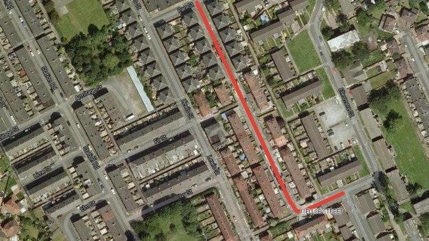 The residential street is lined with terraced houses