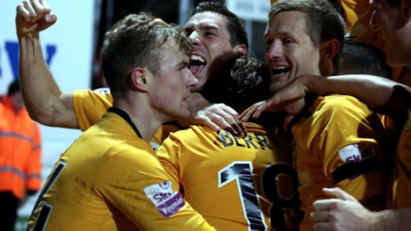 Luke Berry is smothered by his team-mates after scoring the winner.