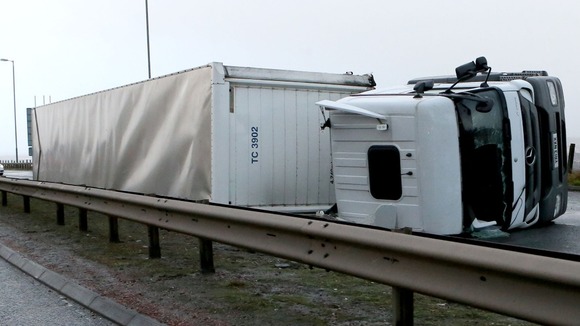 A lorry sits on its side after been blown over in high winds on the A725 near Hamilton