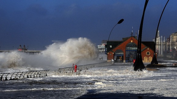 Waves crash on the Blackpool Main Promenade during high tide and a tidal surge.