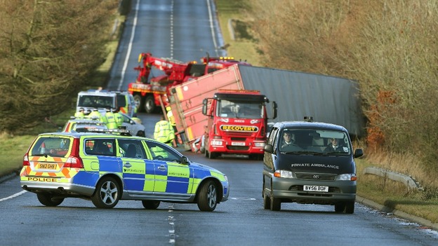 Police and recovery vehicles at the scene where a lorry driver has died as his HGV toppled on to a number of cars on the A801.