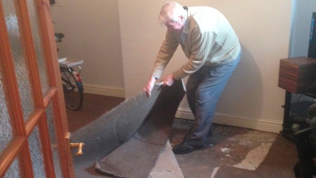 A resident in the worst hit street in Boston ripping up the carpet he had just put down for Xmas