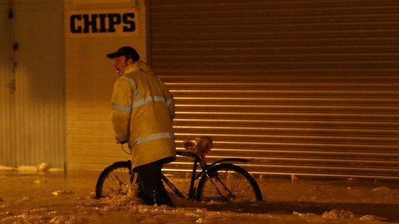 A man pushes his bike through flood water in Great Yarmouth in Norfolk