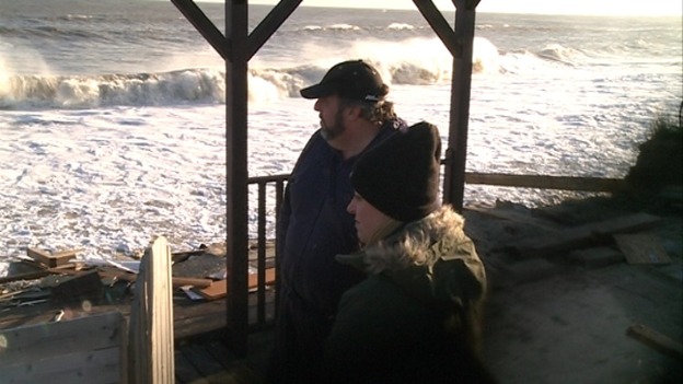 Robin Adams, pictured wearing the cap, looks out to sea.