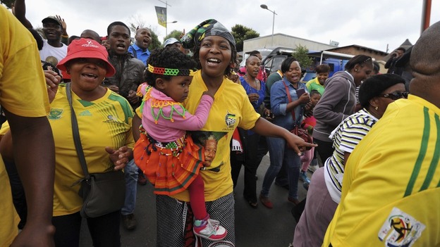 People sing and dance on Vilakazi Street in Soweto where Mandela lived.
