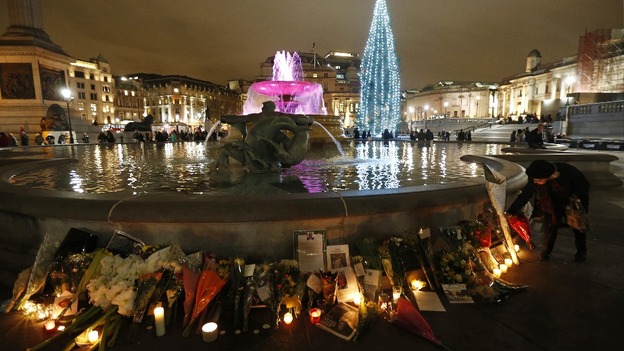 A woman places flowers next to tributes left for Nelson Mandela at Trafalgar Square.