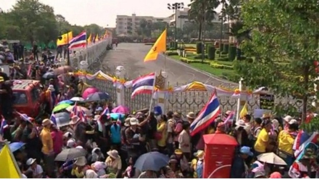 Protesters gather outside the fence in front of Government House