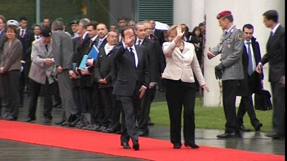 Hollande and Merkel walk the red carpet in Berlin