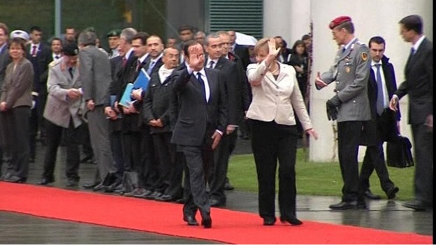 Hollande and Merkel walk the red carpet in Berlin
