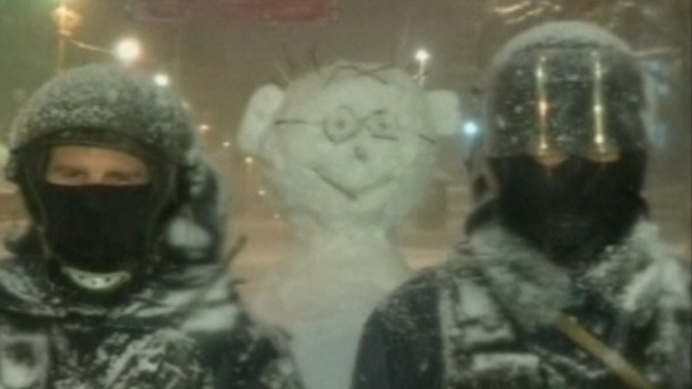 Behind one line of police a snowman has been added to the ranks.