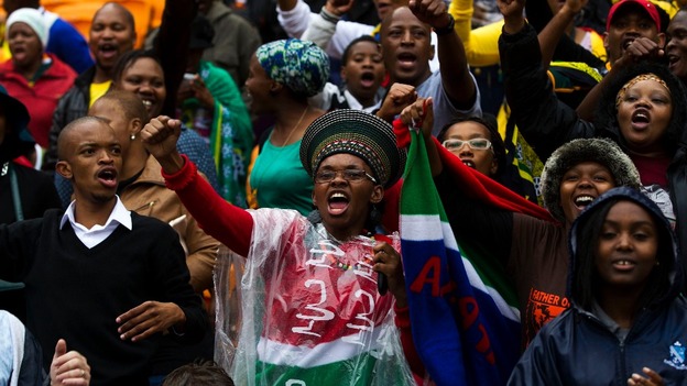 Members of the crowd sing ahead of the memorial
