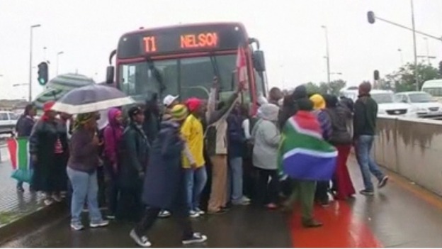 People queue to board a bus for the FNB stadium