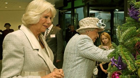 The Queen and the Duchess of Cornwall got in the festive spirit today when they helped decorate a Christmas tree - with a pair of royal baubles.
