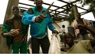 A young boy involved in the looting of a mosque brandishes his knife in front of the cameras.