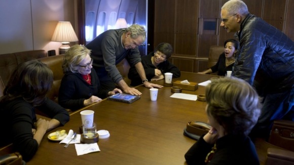 Former President Bush shows photos of his paintings to Lady Michelle Obama and Hillary Clinton.