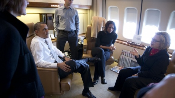 Former Secretary of State Hillary Clinton talks with the Obamas en route to South Africa.