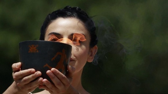 Actress playing High Priestess carries cauldron carrying Olympic Flame during torch lighting ceremony in Greece