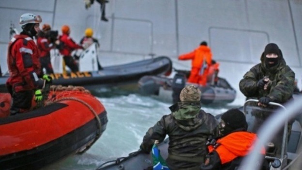 Greenpeace protesters are confronted by Russia coastgaurds near a Gazprom rig that was due to start drilling in the Arctic