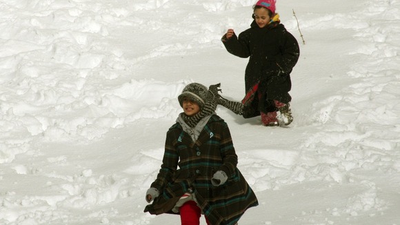 Children making the most of the snow in Amman