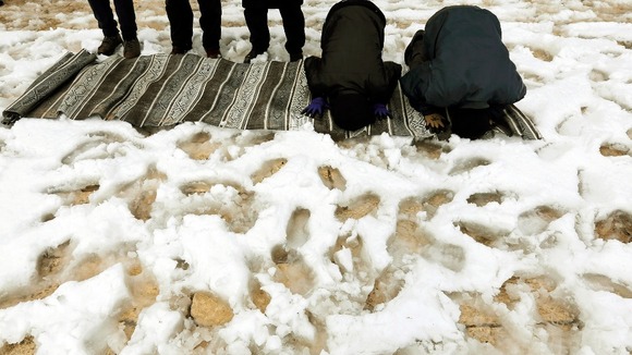 Palestinians pray after a heavy snowfall brought by Mediterranean storm Alexa