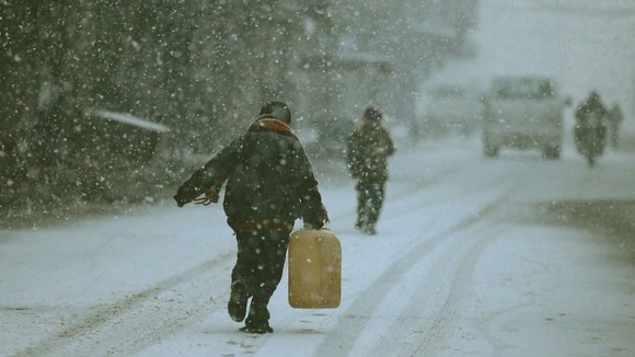 A Damascus resident struggles through slippery streets