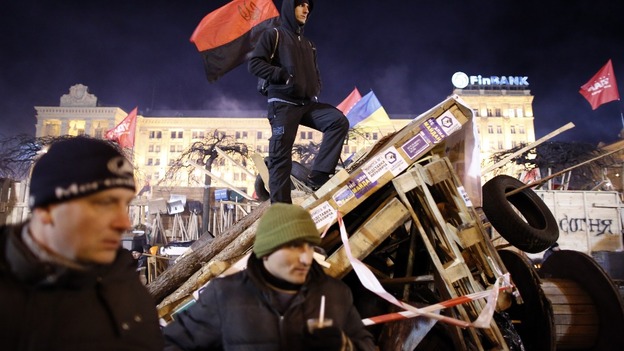 Protesters stand guard at a barricade at Independence Square in Kiev.