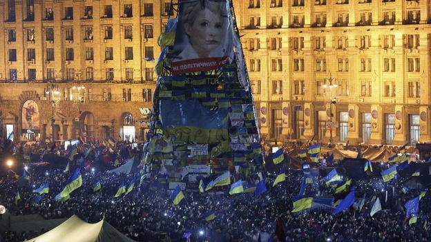 Protesters gather under an image of jailed opposition leader Yulia Tymoshenko.